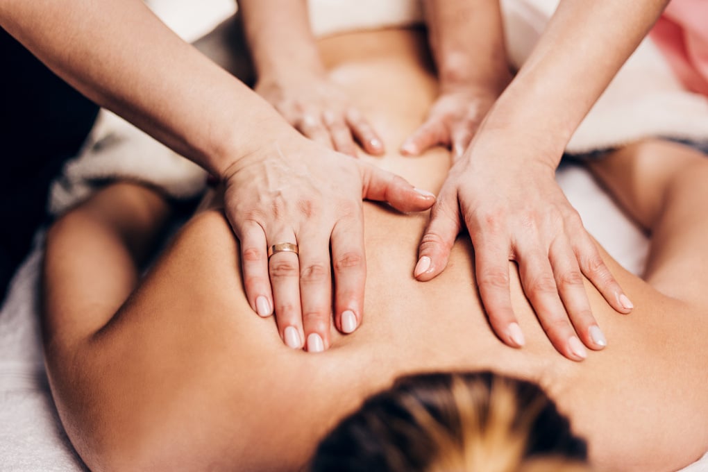 4 hands massage - two masseurs work simultaneously on the patient back - therapeutic massage