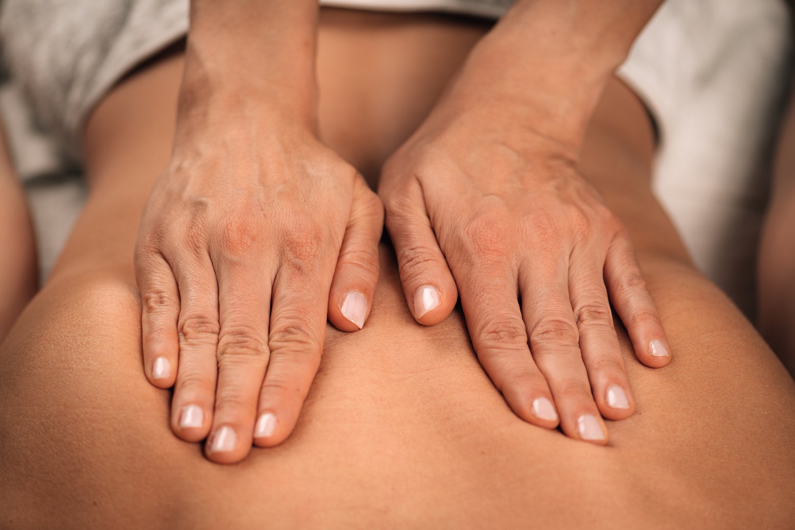 Hands of a Female Therapist doing a Deep Tissue Back Massage